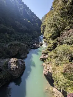 縦位置で撮った峡谷のエメラルドグリーンの川筋と岩。