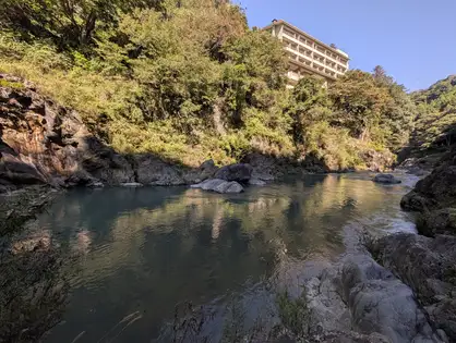 静かな淵。上の斜面に明るい建物がある。