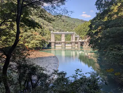 森に囲まれた水門と湖面の映り込み。