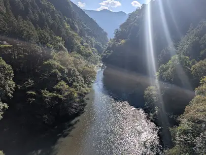逆光の川面。光芒が上から差し込んでいる。